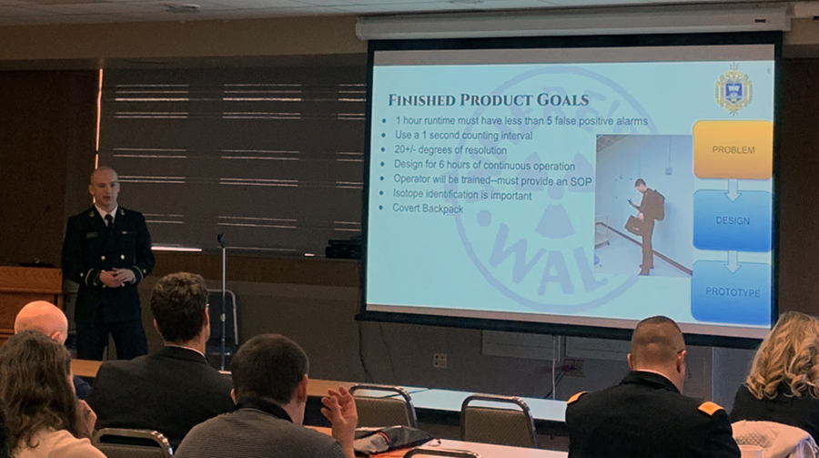 Andrew Reinhart giving talk next to projected image